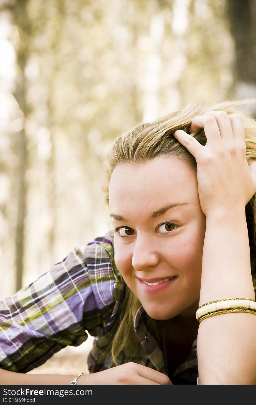 Young laying woman smiling at camera.