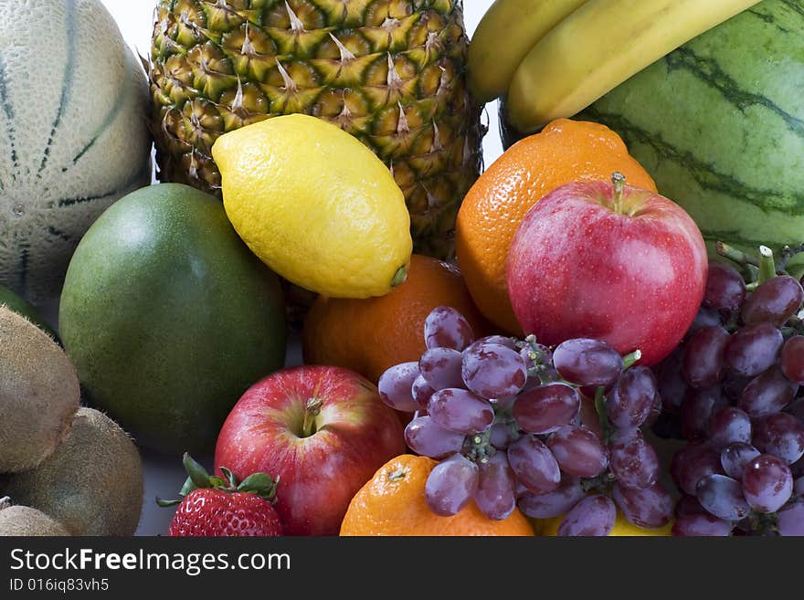 A heap of cut tropical fruits on a white background, very colorful image