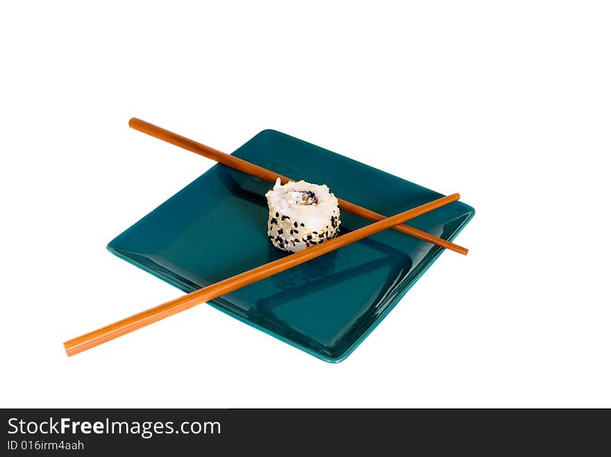 Plate with traditional Japanese sushi, sashimi rolls, shop sticks on the side of the plate. Studio shot.