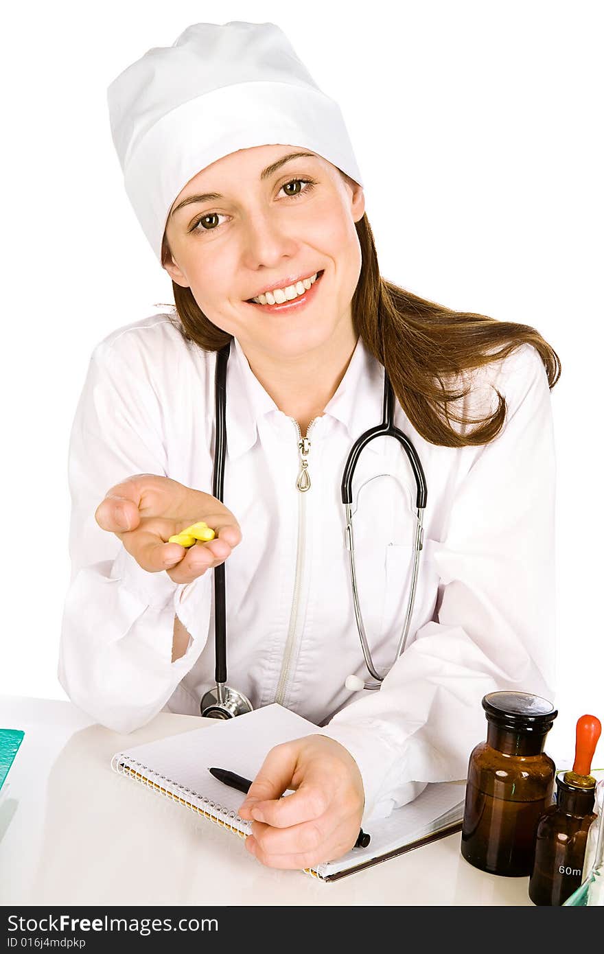 The affable young woman-doctor looks in a shot and holds in a palm some yellow tablets. The affable young woman-doctor looks in a shot and holds in a palm some yellow tablets