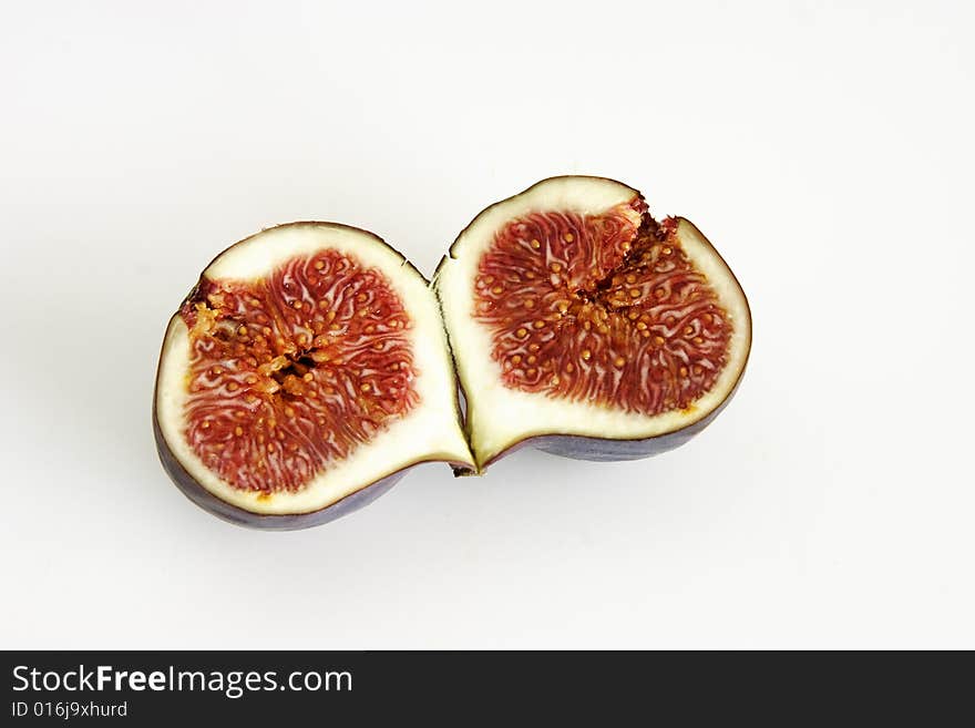 One single fig cut in half showing the seeds inside. One single fig cut in half showing the seeds inside