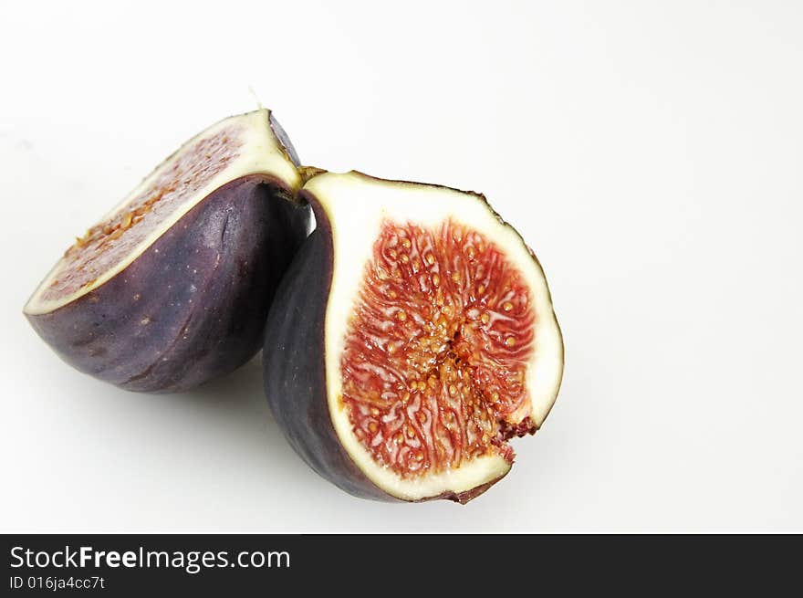 One single fig cut in half showing the seeds inside. One single fig cut in half showing the seeds inside