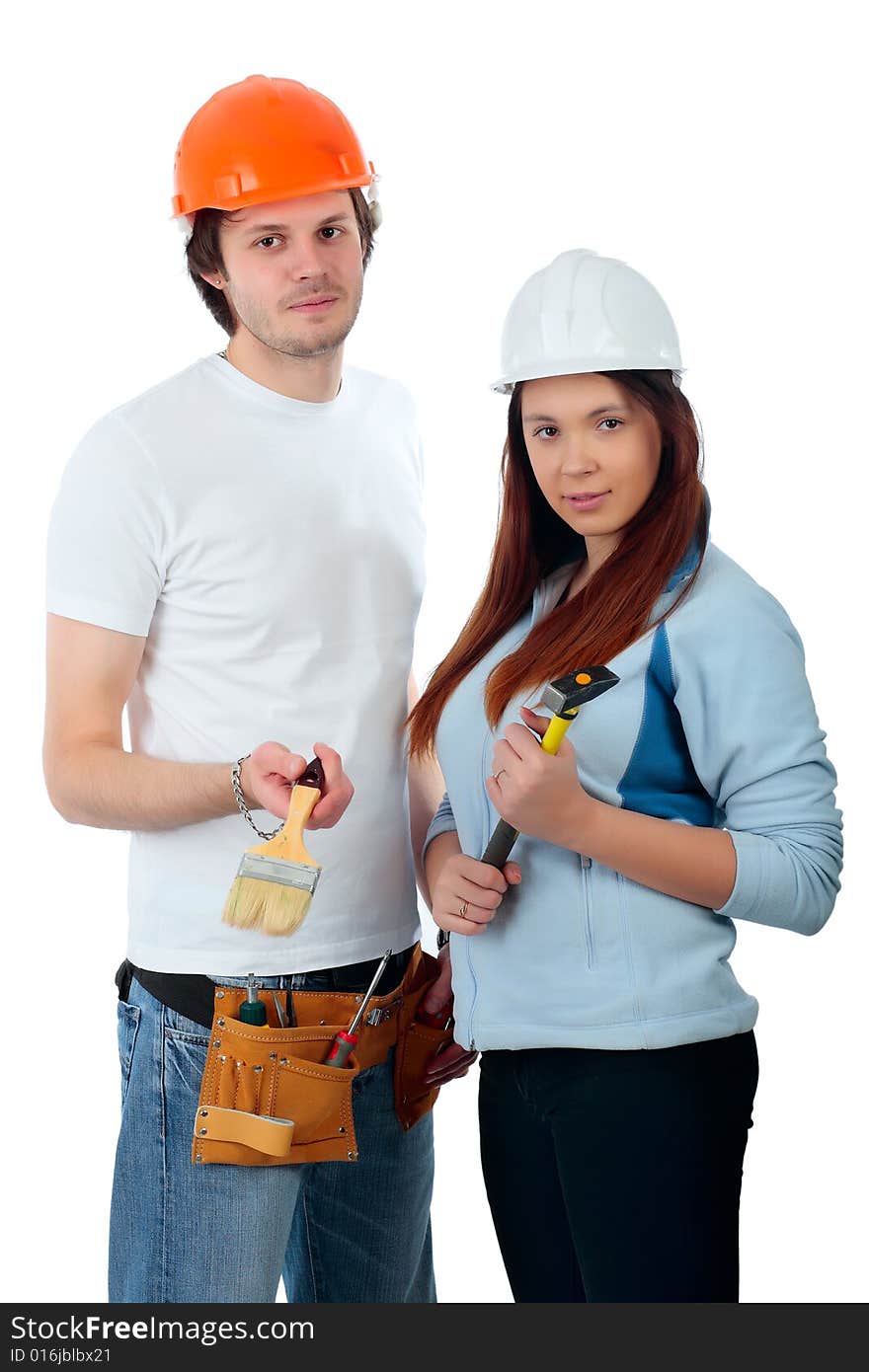 Young pair in a builder uniform with tools. Young pair in a builder uniform with tools.