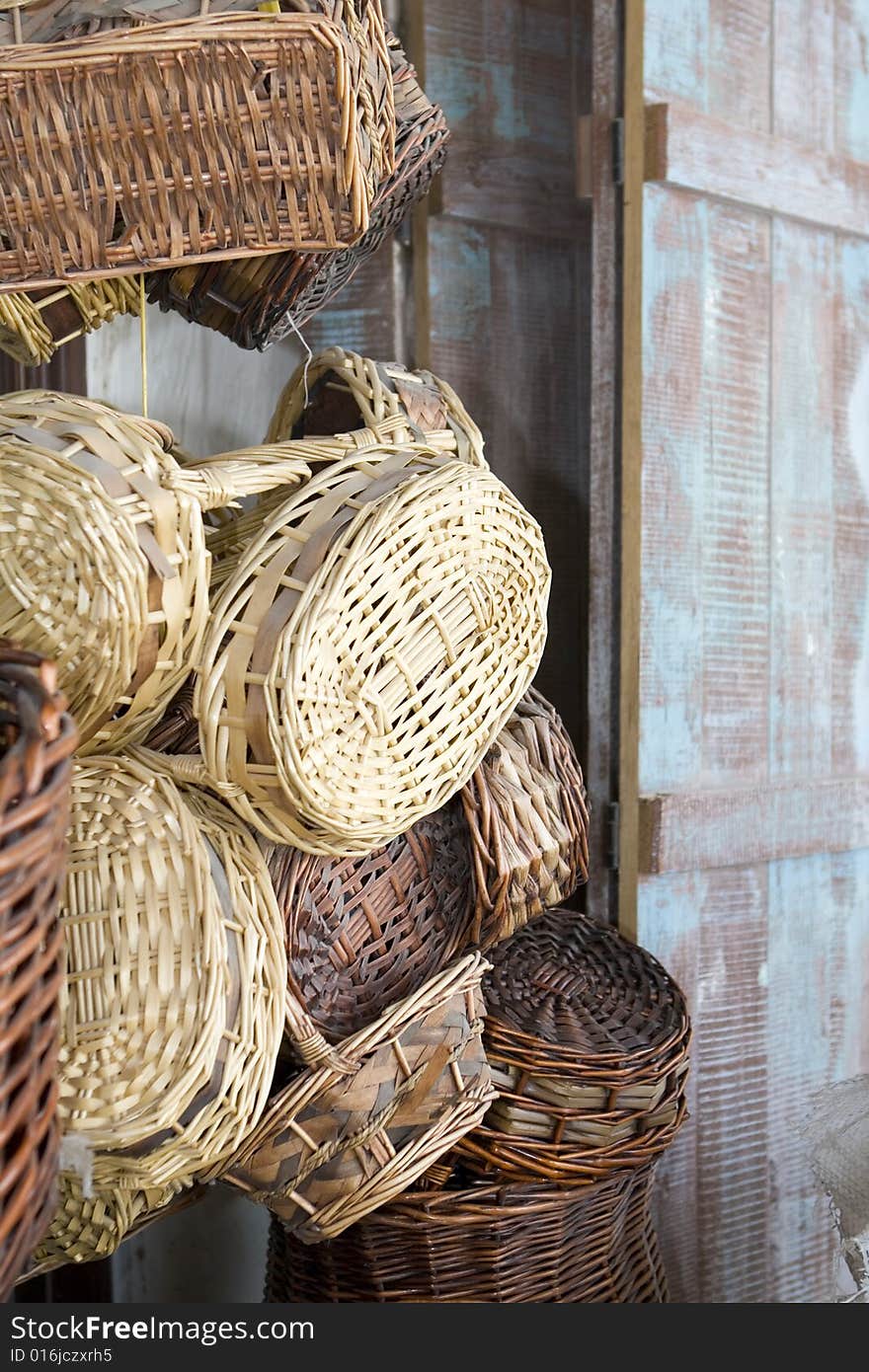 Selection of woven cane baskets next to a old wooden shutter panel. Selection of woven cane baskets next to a old wooden shutter panel