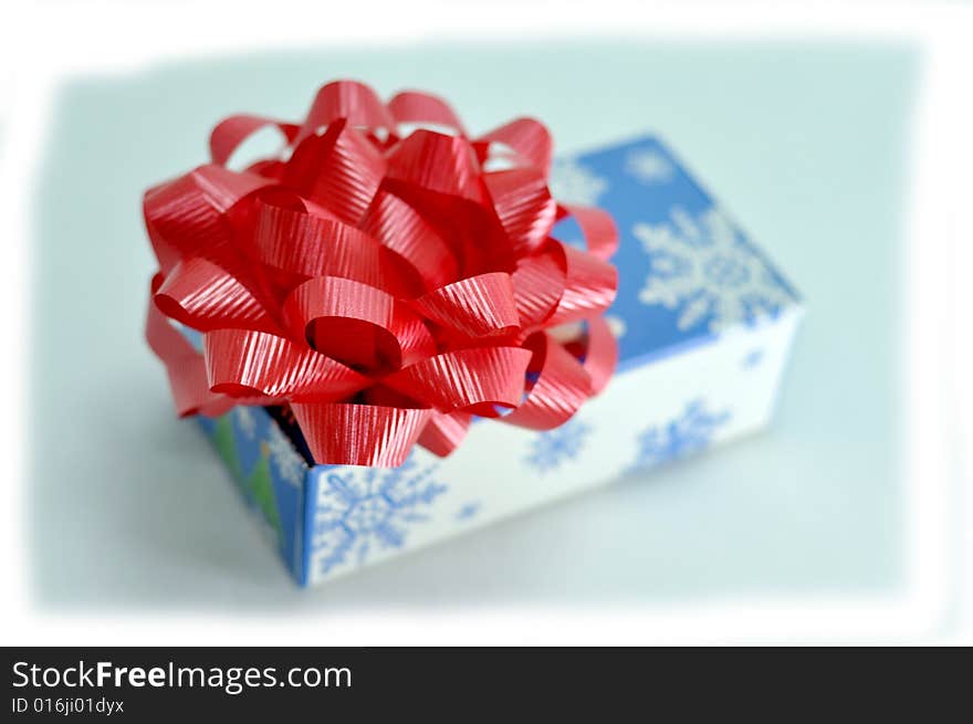 Christmas gift box with red ribbon on top