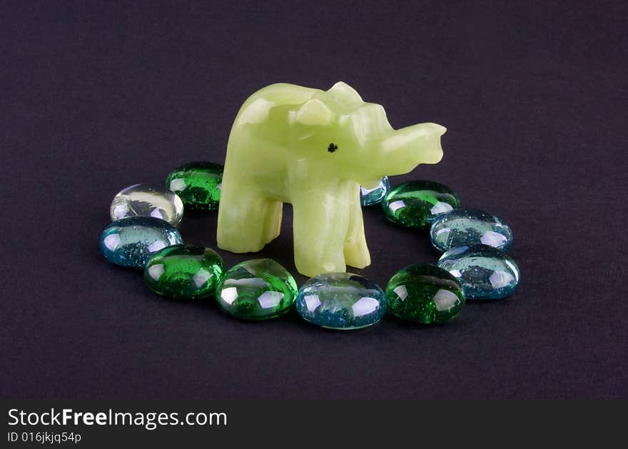 Glass stones and onyx elephant isolated on dark
