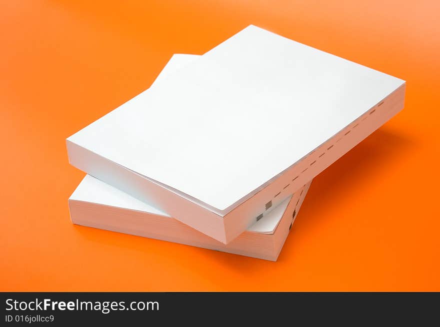 Two blank books over an orange background