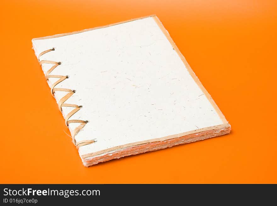 Recycled notepad over an orange background. Recycled notepad over an orange background