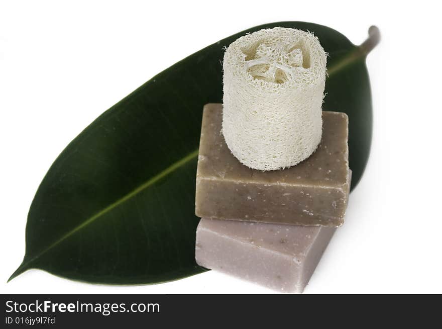 Beautiful spa still life setting with hand made soap and tropical green leaf