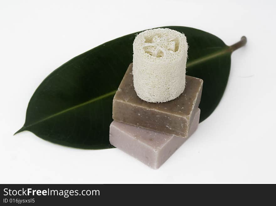 Beautiful spa still life setting with hand made soap and tropical green leaf