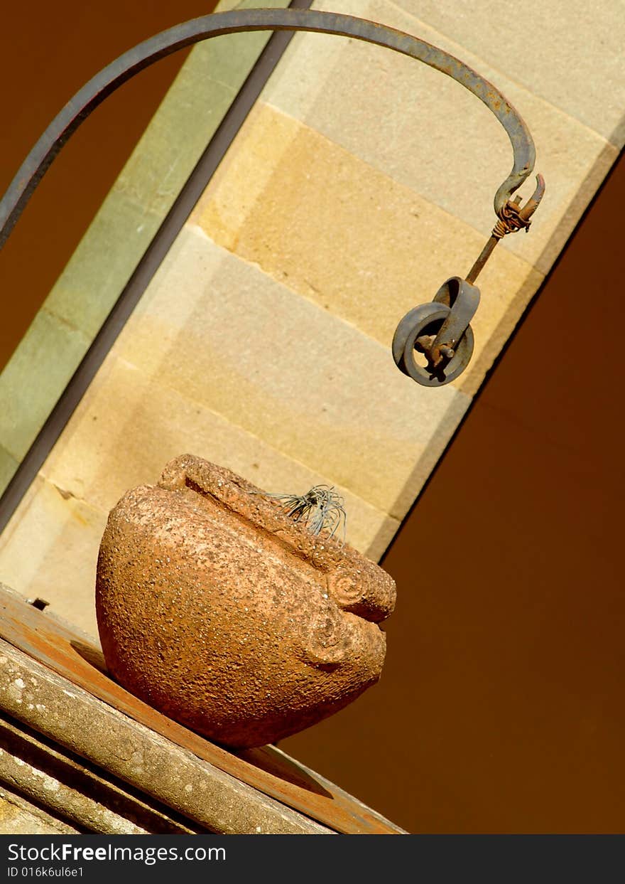 An original shot of an ancient weel with his pulley and a pot on the top. An original shot of an ancient weel with his pulley and a pot on the top