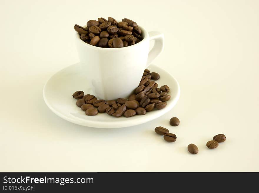 White coffee cup and coffee beans on a light background