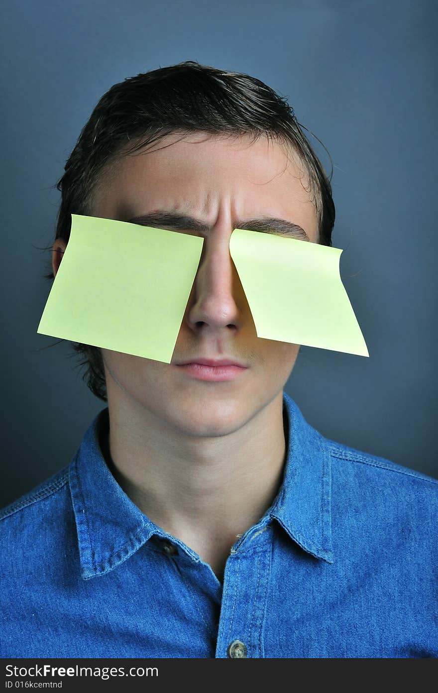 Portrait of a boy holding yellow notes on eye. Portrait of a boy holding yellow notes on eye