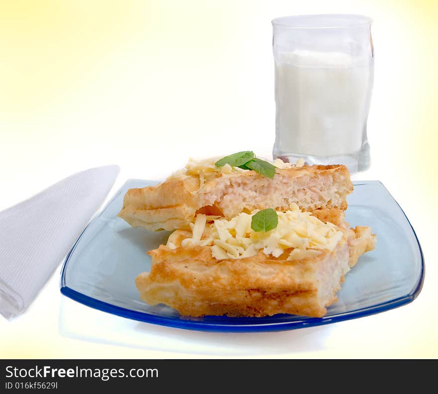 Waffles with cheese on plate and glass of milck