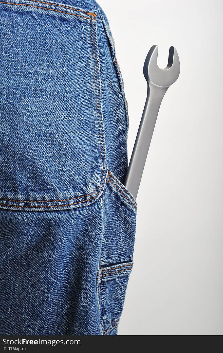 Close up of a wrench in back pocket of jeans. Close up of a wrench in back pocket of jeans