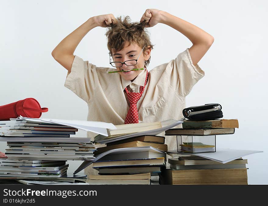 A teen behind of desk tearing his hair. A teen behind of desk tearing his hair