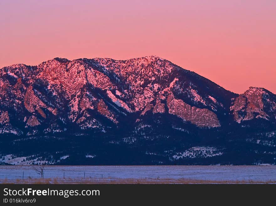 Boulder Colorado's Flatiron Mountains display the reflection of the pink rising sun. Boulder Colorado's Flatiron Mountains display the reflection of the pink rising sun