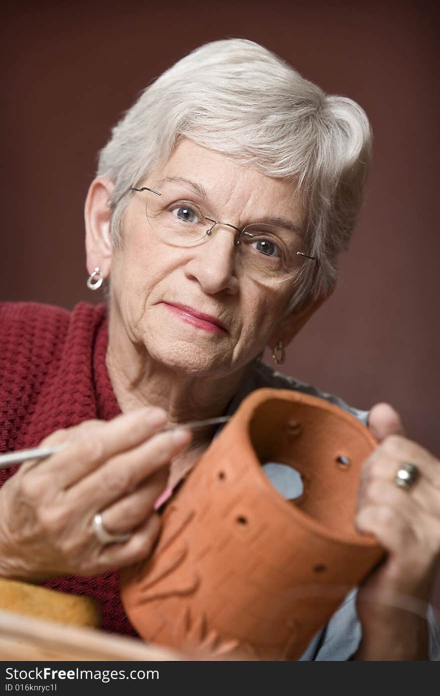 Senior woman working on a clay sculpture. Senior woman working on a clay sculpture