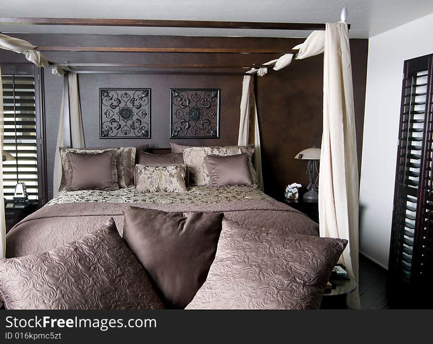 Beautifully decorated bedroom with dark wood florring shutters and four poster bed