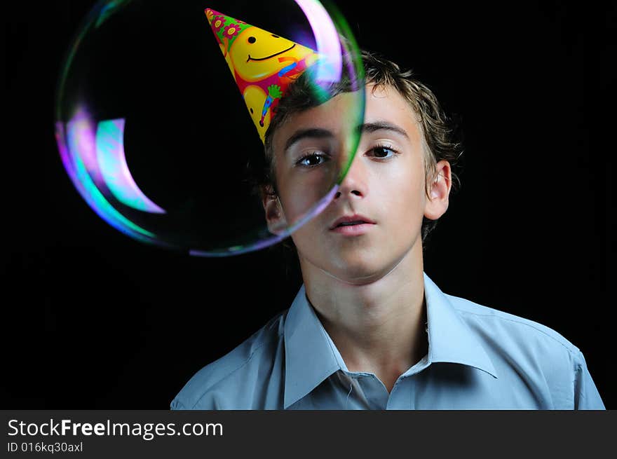 Young boy looking through soap bubbles, children's birthday party