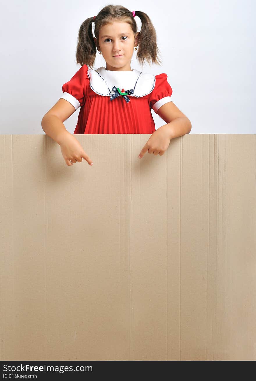 Little girl behind a blank cadboard (adequate for text), close up. Little girl behind a blank cadboard (adequate for text), close up