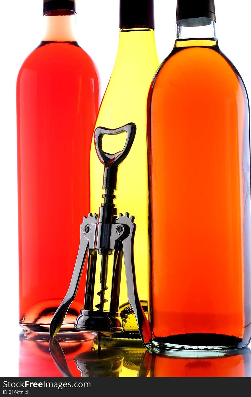 Closeup of three wine bottles and a corkscrew. Closeup of three wine bottles and a corkscrew.