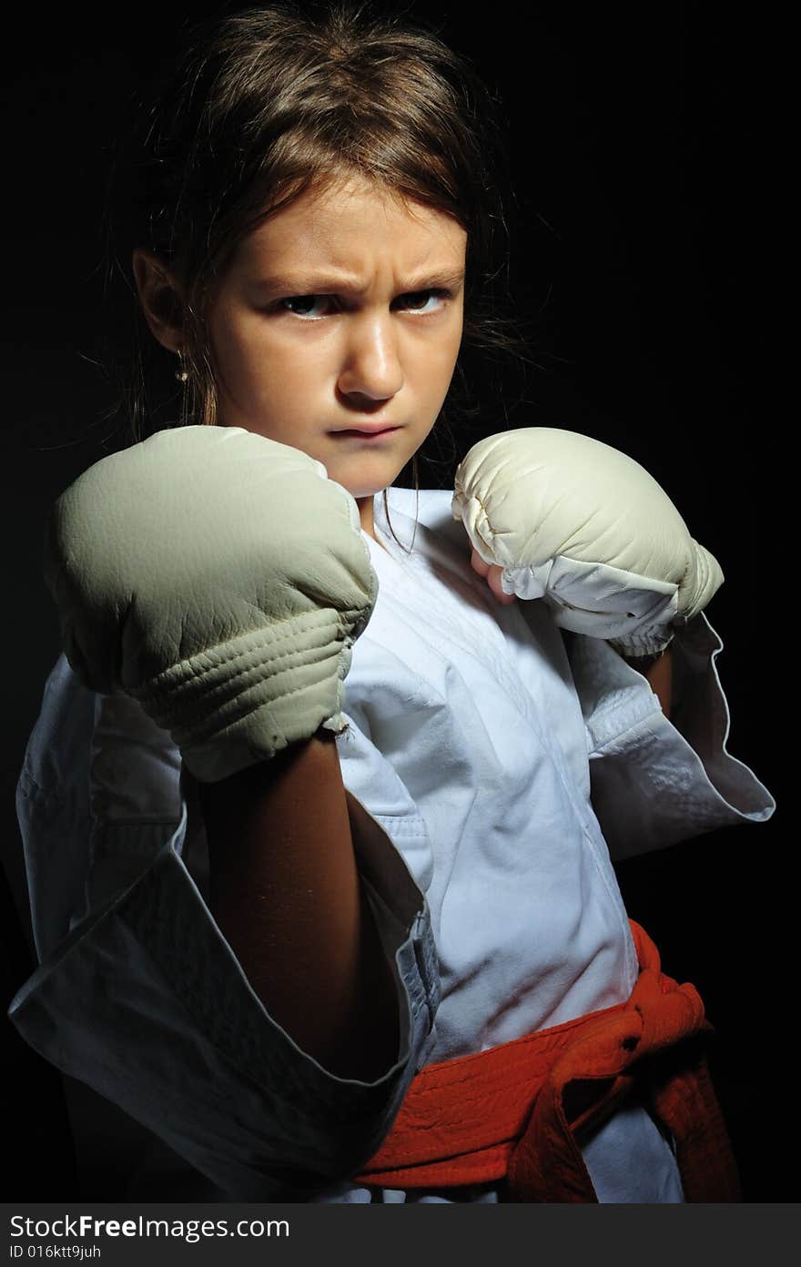 Little girl in martial arts unifor doing karate