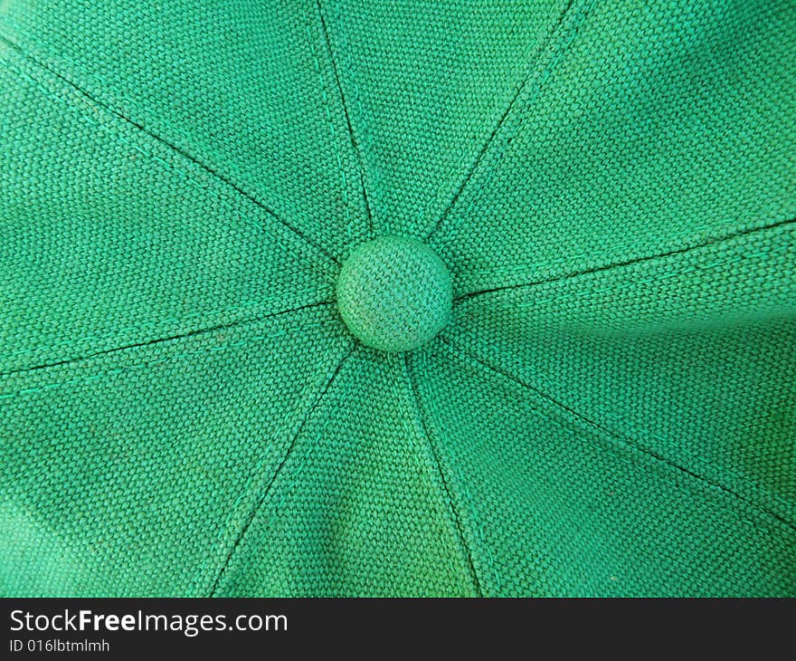 A close up photo of the top of a green hat with fabric texture