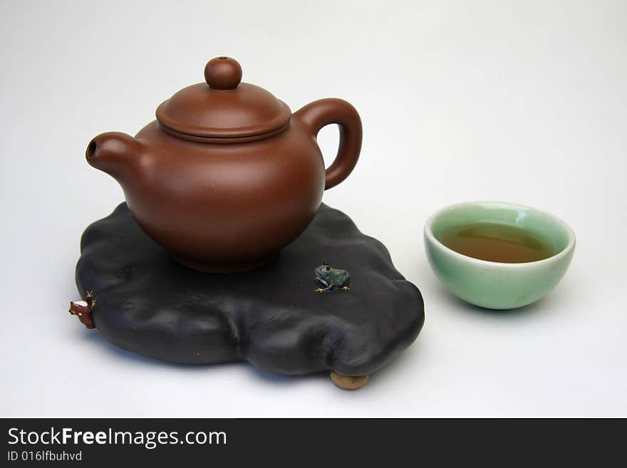 Teacup and teapot on white background，also called zisha teapot in China.