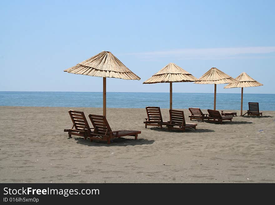 Beach umbrellas and wooden deck shairs