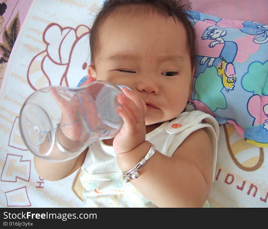 A baby is drinking water with baby's bottle. A baby is drinking water with baby's bottle