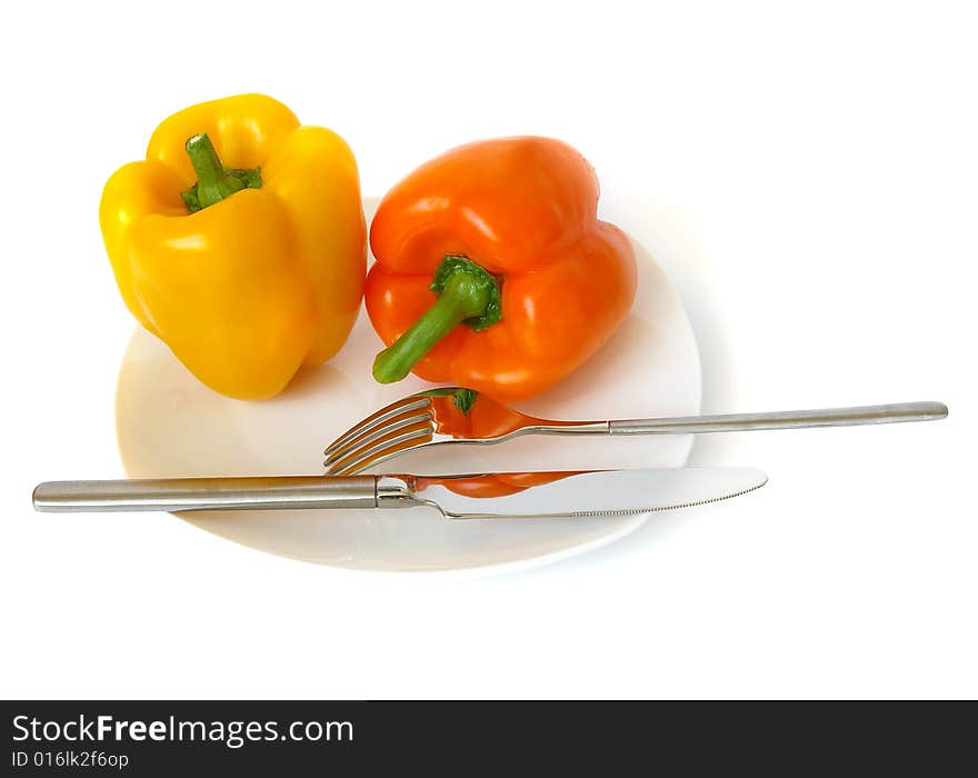 Pepper on a white plate, a knife and a fork. Pepper on a white plate, a knife and a fork