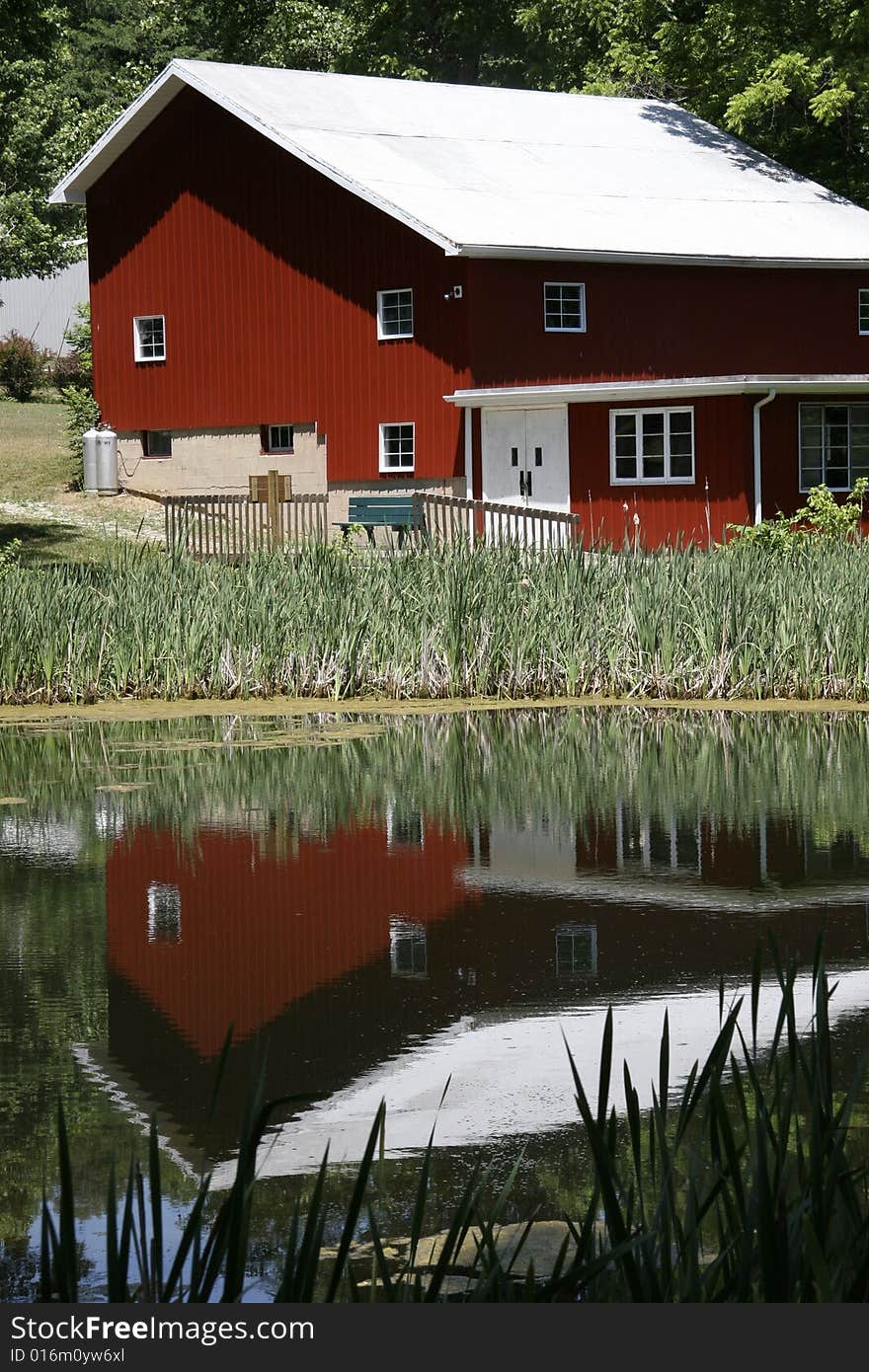 Red barn sitting on the side of the lake with a glassy reflection. Red barn sitting on the side of the lake with a glassy reflection.