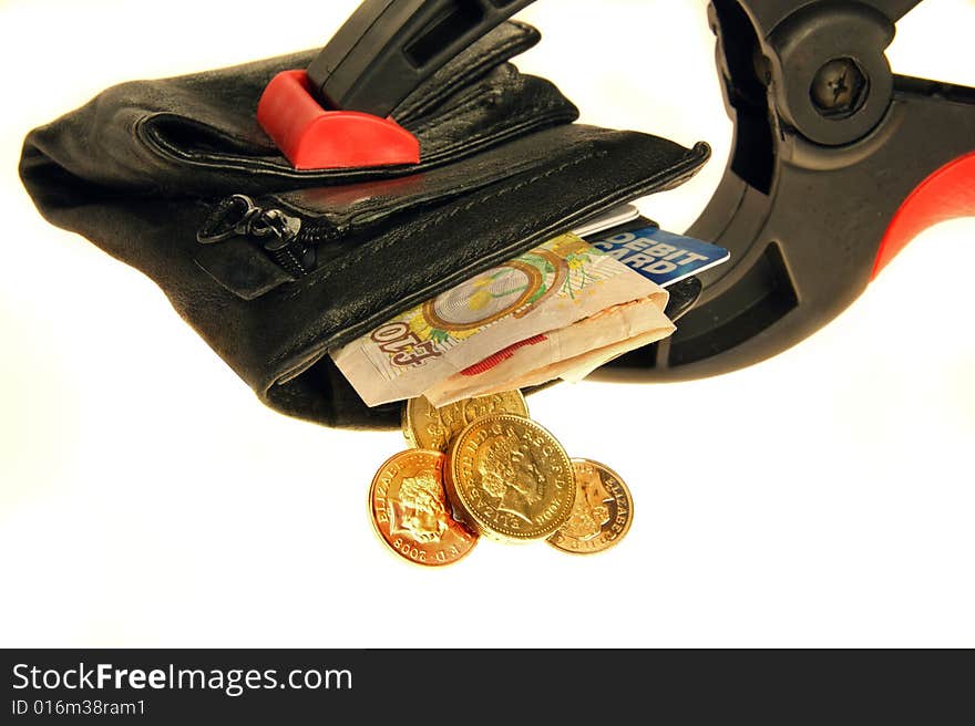 Wallet held in a clamp with credit card and british pound coins/notes. Wallet held in a clamp with credit card and british pound coins/notes