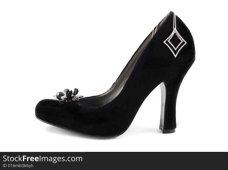 A black dress shoe with a diamond necklace on a white background