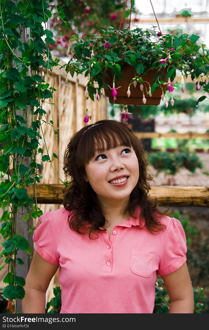 A girl looking at a potted plant. A girl looking at a potted plant