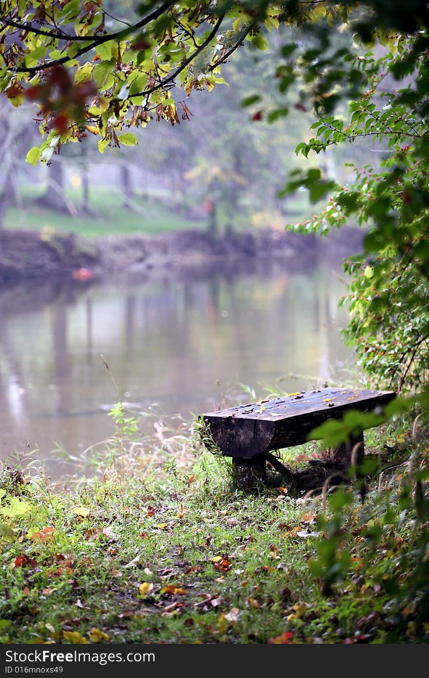 Hand crafted wooden bench on the shore of a misty river in the early morning hours. Hand crafted wooden bench on the shore of a misty river in the early morning hours