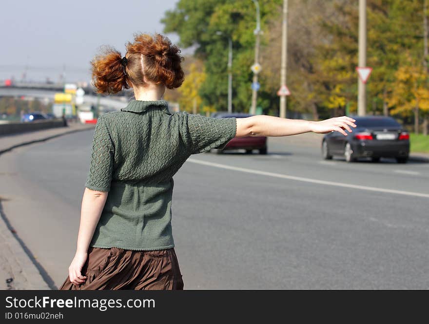 Girl is hitch-hiking on road