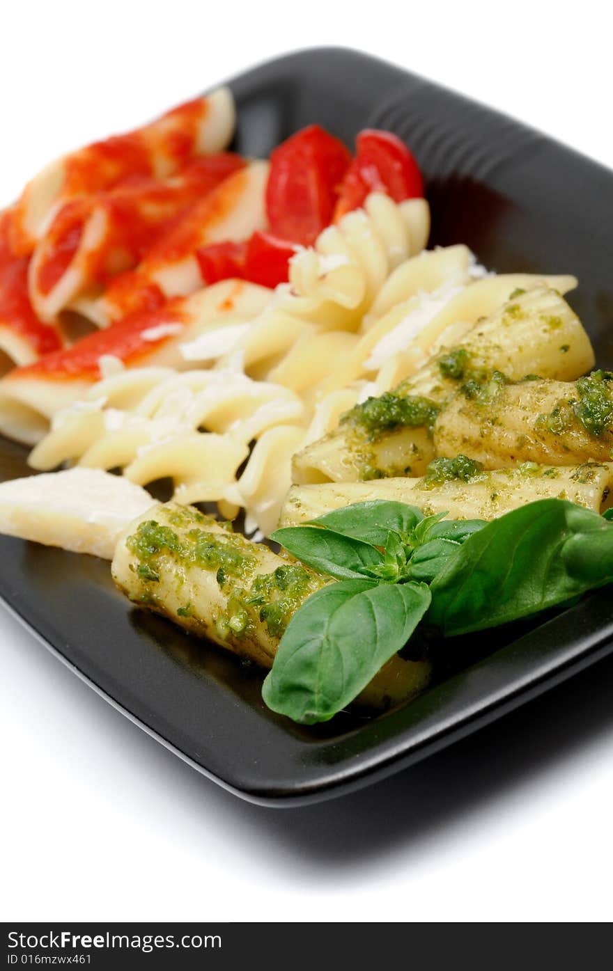 Typical italian pasta arranged with italy flag colors and typical ingredients, pesto, grana, and tomato - shallow dof. Typical italian pasta arranged with italy flag colors and typical ingredients, pesto, grana, and tomato - shallow dof