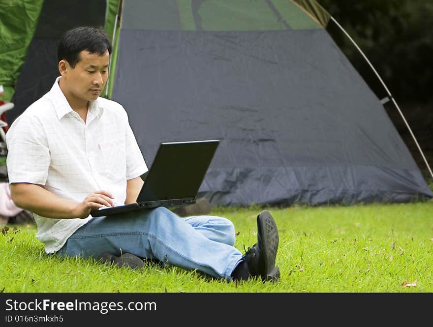 A young man using a laptop outdoors