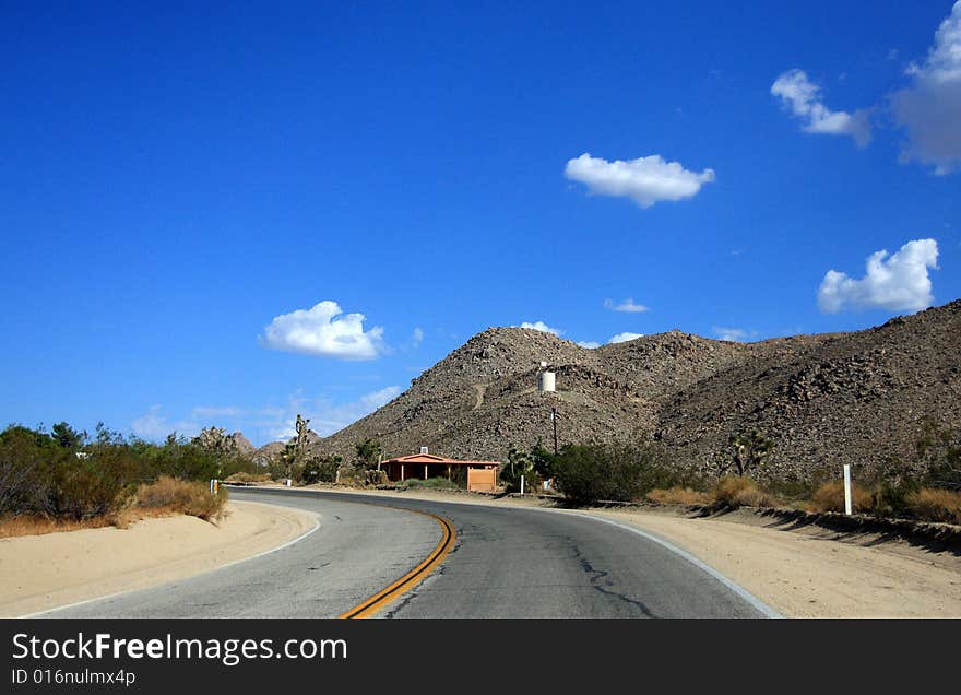 A lone stretch of highway winding through the desert. A lone stretch of highway winding through the desert