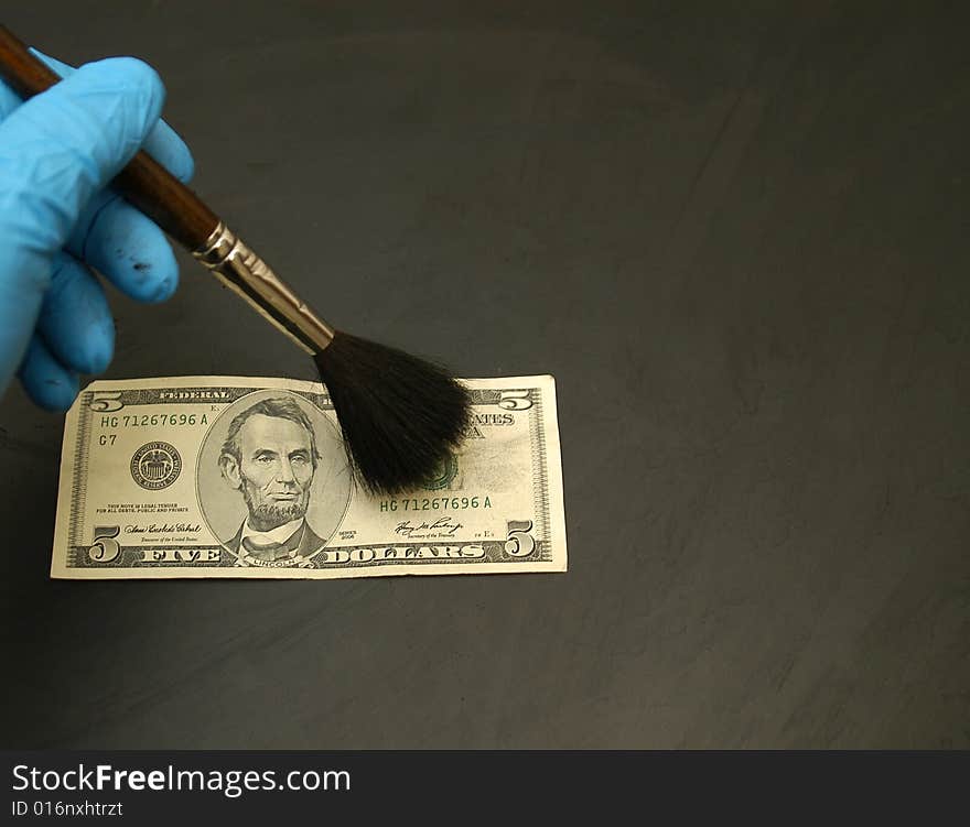 Thumb print developed on a $ 5.00 bill using standard black fingerprint powder.