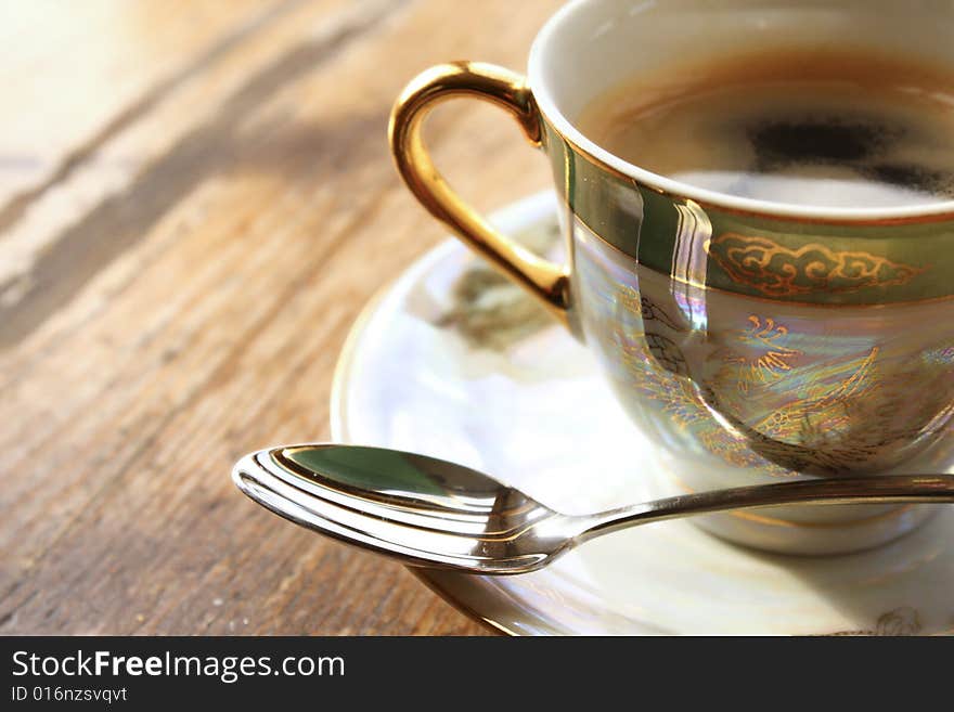 A cup of espresso on a wooden table in colour. A cup of espresso on a wooden table in colour...