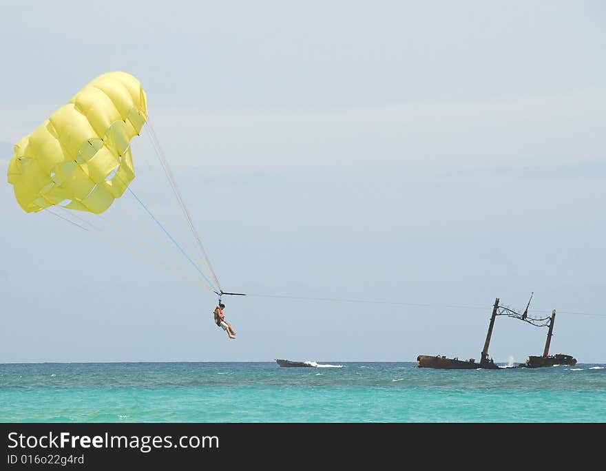 Boat driven parachute flight against blue sky