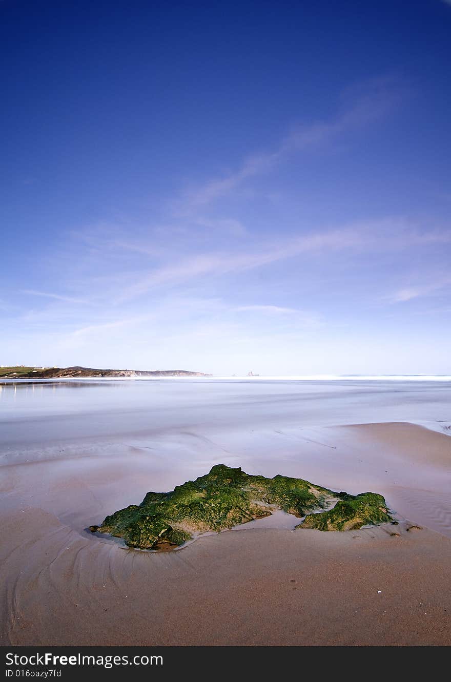 A rock at the beach when is sunrising. A rock at the beach when is sunrising