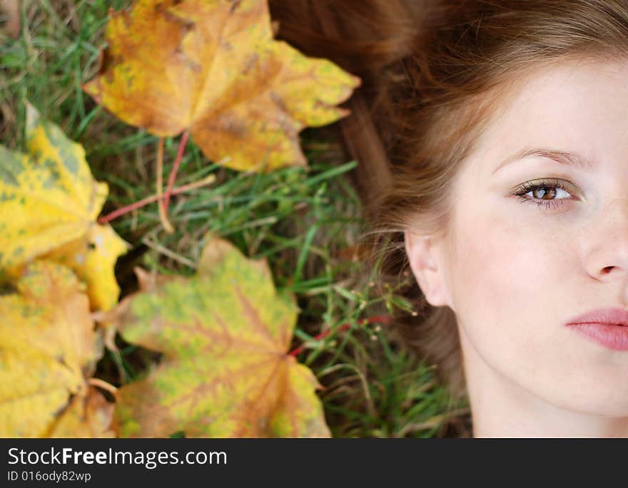 Young beautiful woman with maple leaf around her face