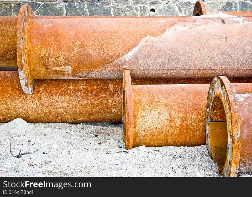 Rusty industrial water pipes on the beach corroded in sea water