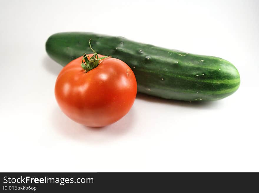 Fresh tomato and cucumber against white background