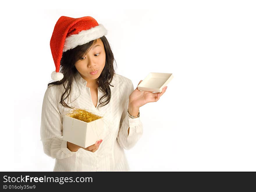 Teenager Asian girl in Santa Claus hat opening a gift box at a Christmas party. Teenager Asian girl in Santa Claus hat opening a gift box at a Christmas party.