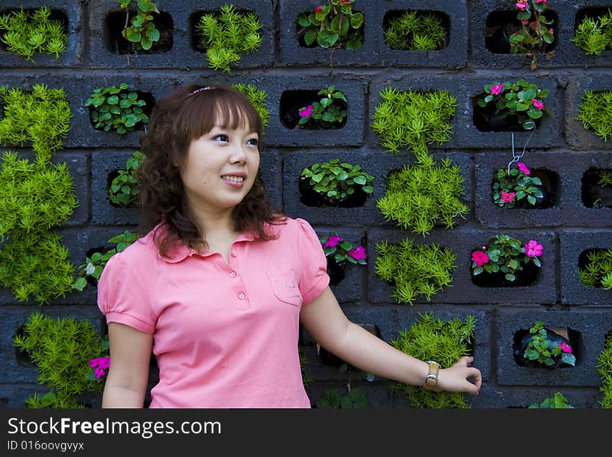 A girl looking at a potted plant. A girl looking at a potted plant